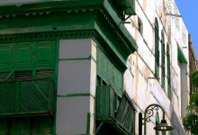 a green and white building with green shutters